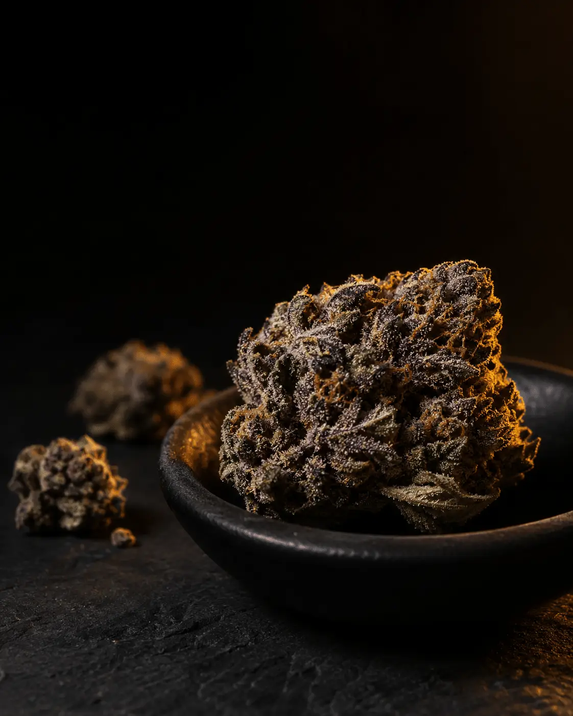 Premium cannabis flower buds in a dark ceramic bowl